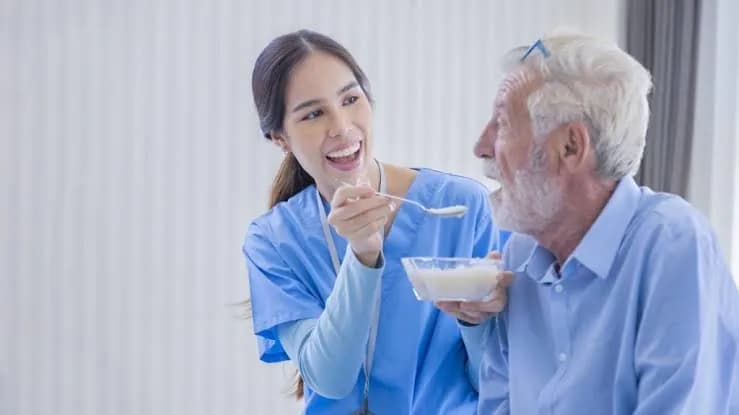 Nurse assisting a participant at mealtime