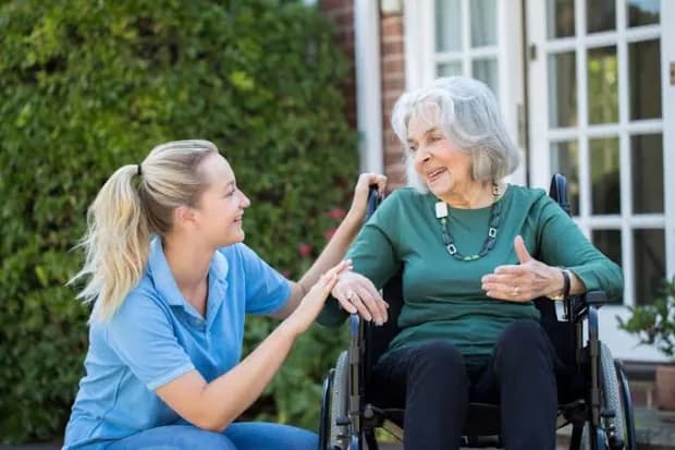 A support worker and participant in the garden