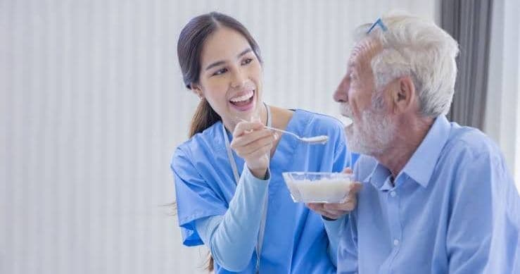 A support worker and participant preparing a meal